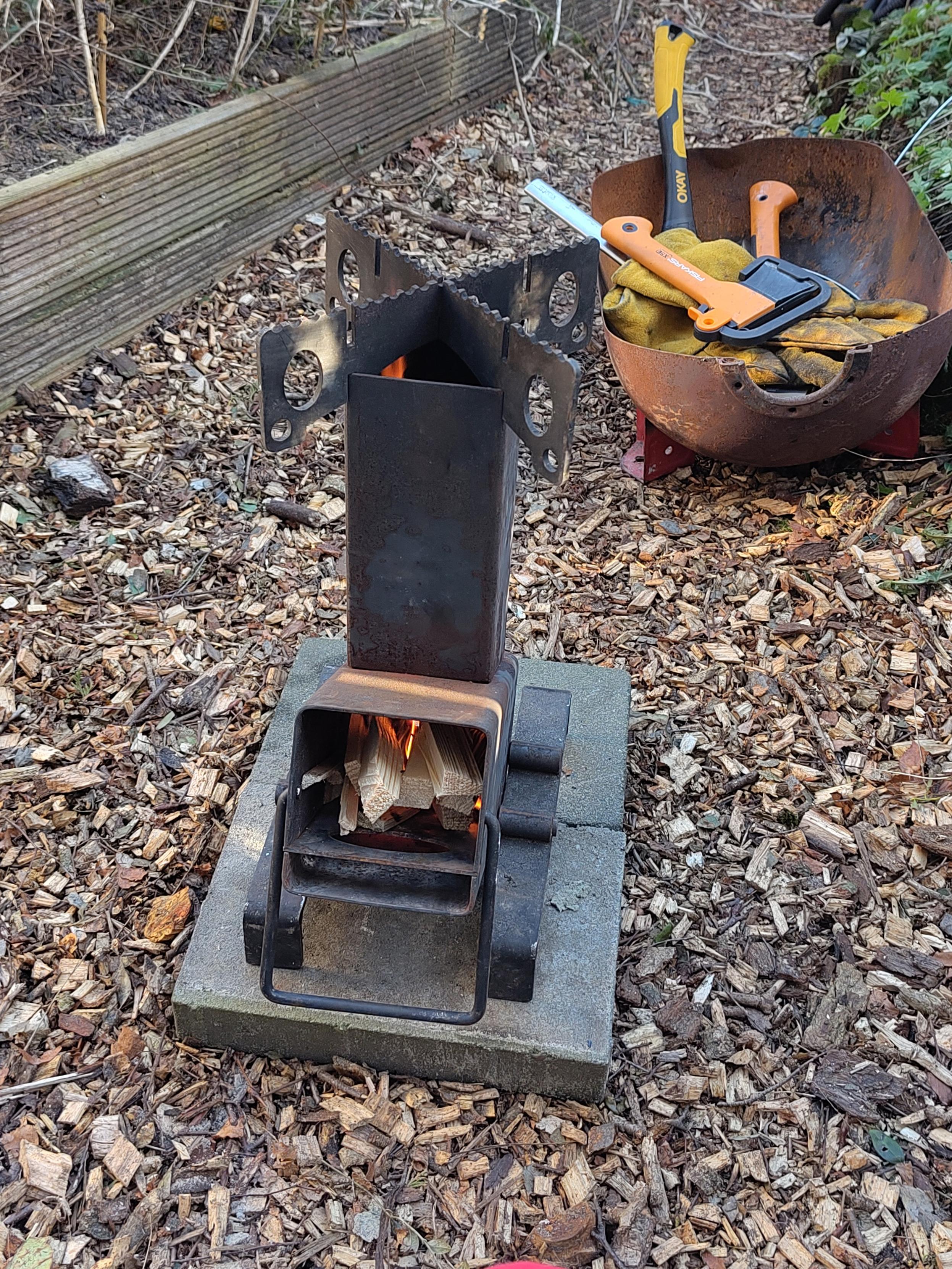 Portable rocket stove met een klein vuurtje er in